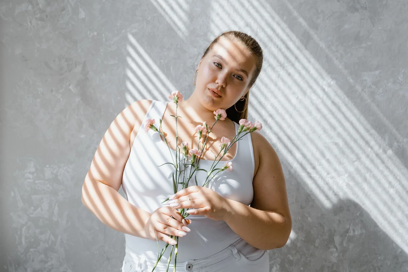 Plnoštíhlá žena v dobře padnoucím outfitu na ulici.
