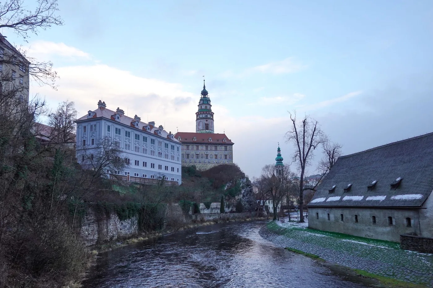 Zámek nad řekou obklopený zelení, typický pohled na jihočeský region