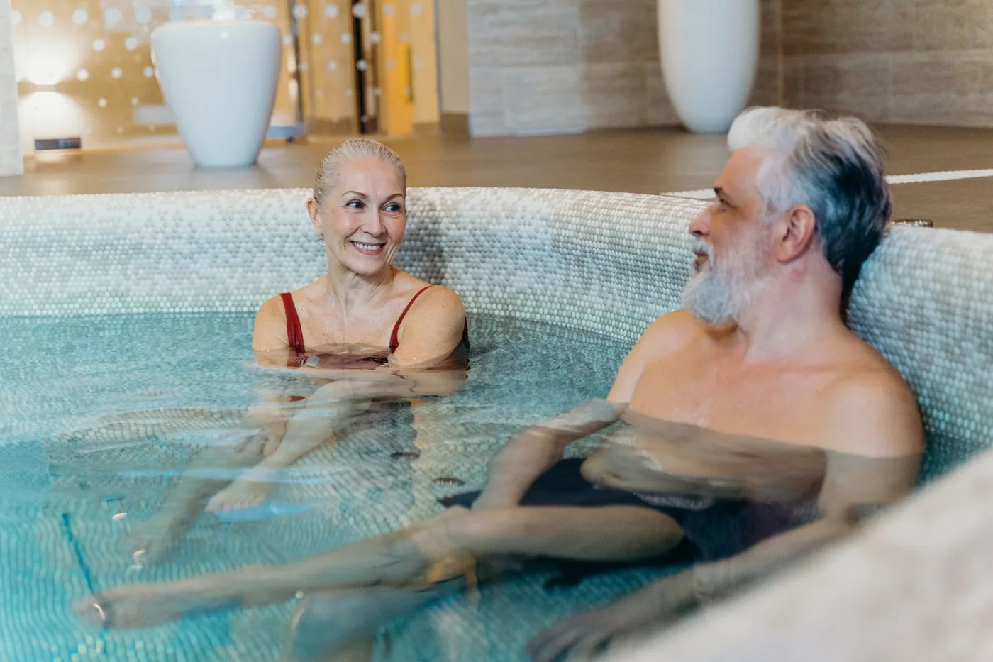 Starší pár odpočívá u bazénu ve wellness zařízení